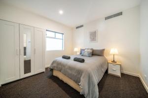 een witte slaapkamer met een bed en een raam bij Level Up Henley in Grange