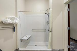 a bathroom with a shower with a sink and towels at Cobblestone Hotel & Suites - De Pere Green Bay in De Pere