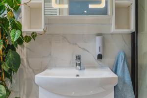 a bathroom with a white sink and a mirror at Baila Casa apartments in Nottingham