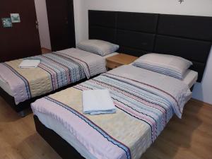 two beds sitting next to each other in a room at Guesthouse Juka in Gospić