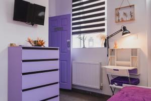 a bedroom with a purple door and a desk at Baila Casa apartments in Nottingham
