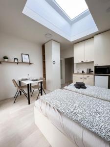 1 dormitorio con 1 cama grande y 1 mesa en Celestial Apartments Brno, en Brno