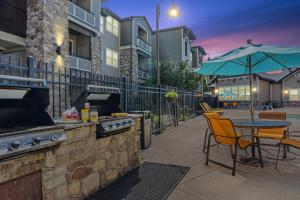 een patio met een grill en een tafel en stoelen bij Steam in the year round hot tub after a Ski trip in South Jordan