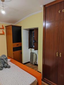 a bedroom with an orange bed and a tv at Apartamento Paseo Fluvial in Tui
