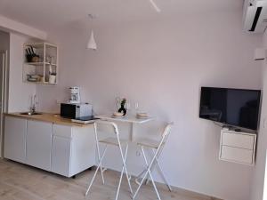 a white kitchen with a table and two chairs at Ida view in Hvar