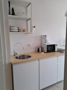 a kitchen counter with a sink and a microwave at Ida view in Hvar