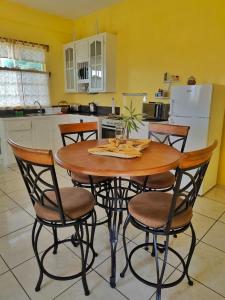 Canouan的住宿－Isla Vista Apartment Canouan，厨房配有木桌和四把椅子