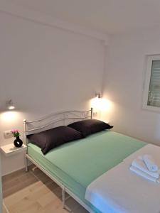 a bed in a room with a white wall at Ida view in Hvar