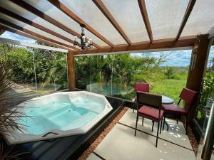 una bañera de hidromasaje en un patio con mesa y sillas en Rancho Flor de Iris - Lago Corumbá IV en Alexânia