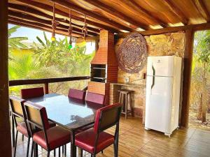 eine Küche mit einem Tisch und Stühlen sowie einem Kamin in der Unterkunft Rancho Flor de Iris - Lago Corumbá IV in Alexânia