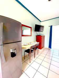 a kitchen with a refrigerator and a table with chairs at Hotel Terraza Inn in Rincon de Guayabitos