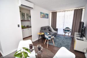 sala de estar con sofá, sillas y TV en Apartamento Altos del boldo, cómodo, en Curicó