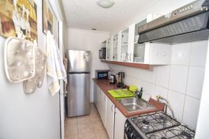 a small kitchen with a sink and a refrigerator at Apartamento Altos del boldo, cómodo in Curicó