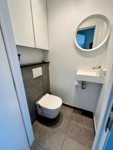 a bathroom with a toilet and a sink and a mirror at Oostende zeezicht Majestic 1 in Ostend