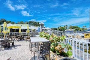 un patio con mesas, sillas y sombrillas en Comfy, Private, Great Wi-Fi , Heated Pool, TikiBar, en Sarasota