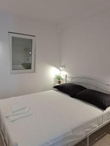 een wit bed in een witte kamer met een spiegel bij Sea view in Hvar