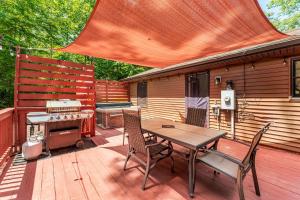 a wooden deck with a table and chairs and a grill at Lake Getaway (paddle boards included) in Mineral