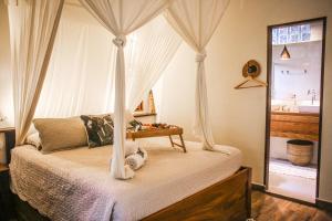 sypialnia z łóżkiem z baldachimem i oknem w obiekcie Villa Arumã Pousada w mieście Alter do Chao