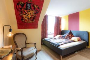 sypialnia z łóżkiem, krzesłem i flagą w obiekcie - Magical Harry Potter apartment in Duisburg - 2 Mins Central Station Hbf - Kingsize Bed & Netflix - w mieście Duisburg