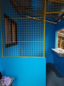 Habitación azul con una pared de azulejos azules y una ventana en ashing kobe guest house 