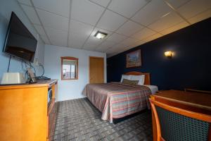 a hotel room with a bed and a flat screen tv at Sleep-ees Inn in Shields