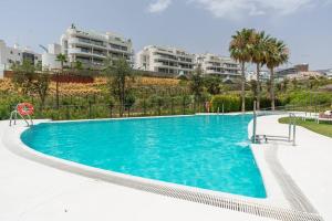 ein großer Pool mit blauem Wasser vor einigen Gebäuden in der Unterkunft Veraxul Higueron West in Fuengirola