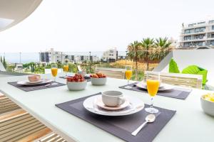 uma mesa com pratos de comida e bebidas numa varanda em Lux Resort Higueron West VXL em Fuengirola
