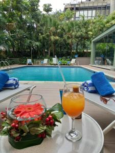 una bebida en una mesa junto a la piscina en HOTEL ALTAMIRA SUITES, en Caracas