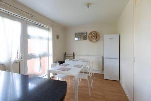 a kitchen with a white table and a white refrigerator at Ideal home with private parking for contractors & groups in Birmingham