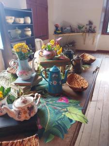 uma mesa com um monte de vasos sobre ela em Bonserá do Madeira em Lavras