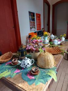 a wooden table with dishes and vases on it at Bonserá do Madeira in Lavras