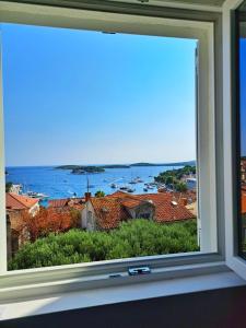 een raam met uitzicht op het water en de gebouwen bij Sea view in Hvar