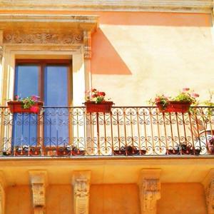 balcone con piante in vaso e finestra di U Palazzieddu Rooms a Pachino