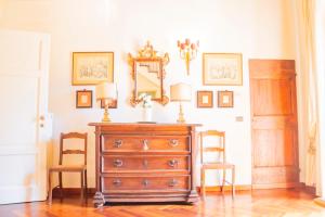 Una cómoda con dos lámparas y dos sillas en una habitación. en Machiavelli Superior House, en Florencia
