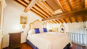Un dormitorio con una gran cama blanca con almohadas azules. en Machiavelli Superior House, en Florencia