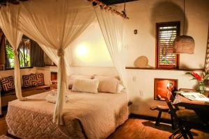 sypialnia z łóżkiem z baldachimem i biurkiem w obiekcie Villa Arumã Pousada w mieście Alter do Chao