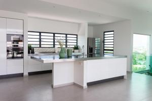a kitchen with white cabinets and a counter top at Charming Villa With Breathtaking View Over The Spanish Water in Willemstad