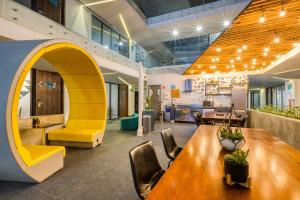 an office with a table and chairs and a yellow arch at Eazy Rio by ULIV in Tijuana