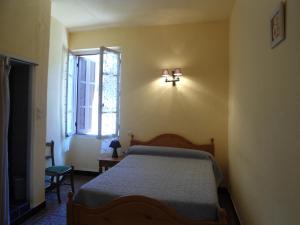 1 dormitorio con 1 cama y una luz en la pared en Hotel Les Calanques, en Piana
