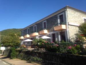 a building with umbrellas and flowers in front of it at Hotel Les Calanques in Piana