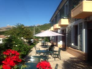 patio con tavolo, sedie e ombrellone di Hotel Les Calanques a Piana