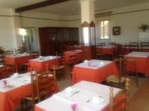 een leeg restaurant met rode tafels en stoelen bij Hotel Les Calanques in Piana