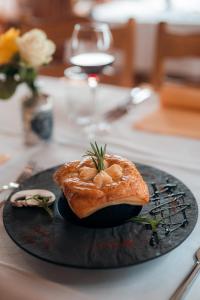 un pastelito en un plato negro en una mesa en Relais Fleuri en Chermignon-dʼen Bas