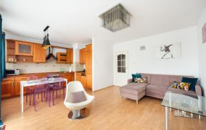 華沙的住宿－KEN 54 2-Bedroom Apartment，厨房以及带沙发和桌子的客厅。