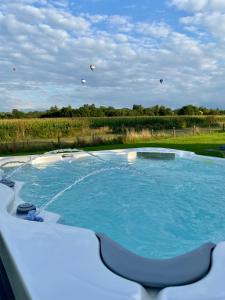 a swimming pool with kites flying in the sky at Stunning modern home set in beautiful grounds. in Bath