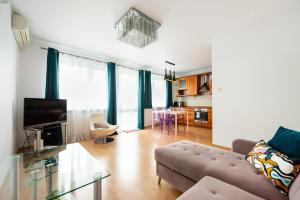 uma sala de estar com um sofá e uma mesa em KEN 54 2-Bedroom Apartment em Varsóvia