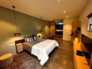 a bedroom with a large bed in a room at Plaisances, les plaisirs du bord de Meuse - Chambre d'hôtes avec baignoire spa in Profondeville