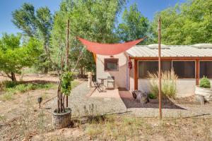 una piccola casa con una tenda rossa in un campo di Cozy Santa Fe Getaway - Near Creek and Casinos a Pojoaque