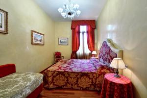 Un dormitorio con una cama y una ventana con una lámpara de araña. en Residence Odoni en Venecia