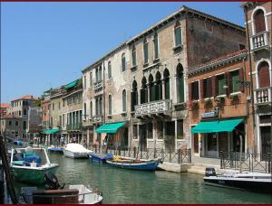 a group of boats in a canal next to buildings at Residence Odoni in Venice